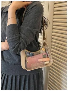 Détail en gros plan d'un sac à bandoulière transparent en PVC avec garniture beige