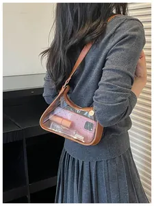 Détail d'un sac à bandoulière en PVC transparent avec une bordure en cuir marron