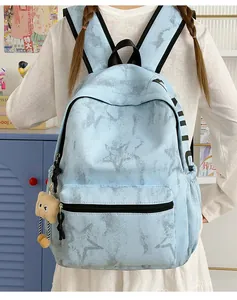 Nahaufnahme eines hellblauen Rucksacks mit Sternenmuster, getragen von einer Schülerin