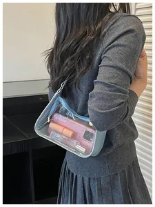 Sac sous le bras tendance en PVC transparent sur un modèle en pull en tricot gris