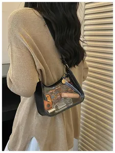 Détail d'un sac bandoulière transparent en PVC avec bordure noire porté par un modèle