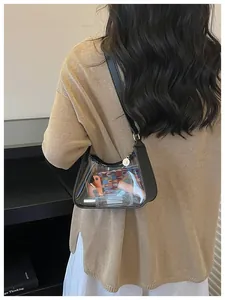 Vue détaillée d'un sac sous les aisselles en PVC transparent avec bandoulière noire sur un pull