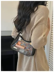 Élégant sac à bandoulière en PVC transparent avec bordure noire et accents dorés sur modèle