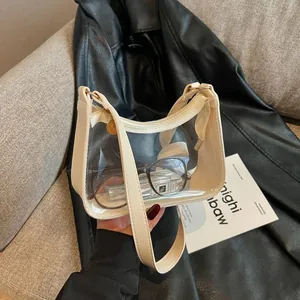Sac à bandoulière tendance en PVC transparent avec bordure crème dans un décor de style.