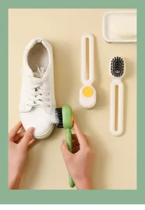 Detailed view of the press-type liquid dispensing shoe brush cleaning a white sneaker