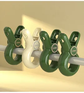 Close-up of four heavy duty windproof plastic quilt clips in green and cream on a pole