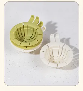 Detailed view of olive green and off-white cartoon kitchen sink drain strainers