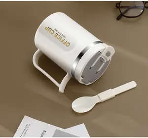 Detailopname van een witte rvs kantoormok met een bijpassende opvouwbare lepel.