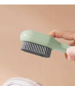 Close-up detail of a liquid dispensing shoe cleaning brush with soft grey bristles