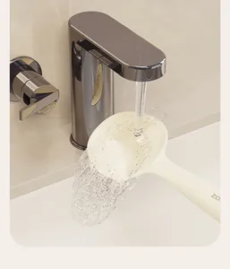 Détail d'une cuillère à riz en silicone à ventouse rincée sous l'eau du robinet