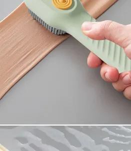 Close-up of hand-held liquid dispensing brush cleaning fabric with soft bristles
