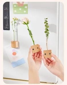 Close-up van houten magnetische reageerbuisvazen met verse bloemen op een koelkast
