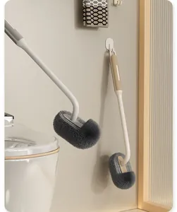 Toiletborstel met lange steel en zachte haren, aan de muur hangend voor handige opslag