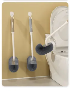 Detailoverzicht van wandgemonteerde toiletborstels in de badkamer met gebogen haren.