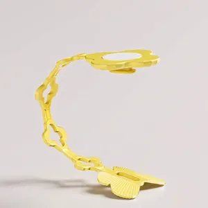 Organisateur de câbles en silicone jaune en forma de fleur pour petits appareils.