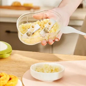 Manual garlic chopper with stainless steel blades for efficient minced garlic preparation.