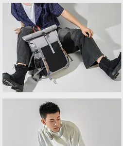 Lifestyle view of grey and black roll-top backpack for men shown with a model