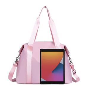 Detailed view of the large pink nylon travel bag compared to a tablet for size reference