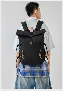 Detailed view of large capacity black roll-top commuter backpack worn by male model