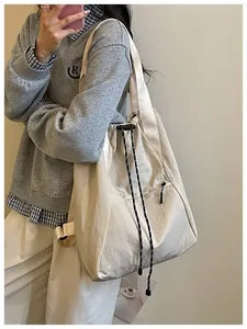 Photo lifestyle d'un sac à cordon crème léger montrant la texture du tissu de près