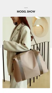 Large capacity beige nylon travel bag worn by a model as a fashionable shoulder bag