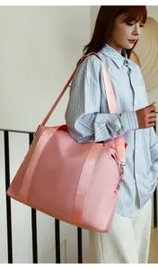 Asian model carrying a large pink nylon travel duffel bag with comfortable shoulder strap