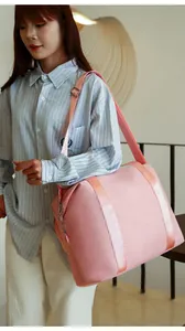 Asian model carries a large pink nylon travel shoulder bag in a lifestyle setting