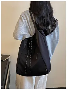 Sac à dos de sport noir léger à cordon porté par une personne dans un décor minimaliste