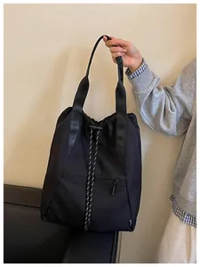 Détail d'un sac seau noir avec cordon de serrage et larges bretelles robustes