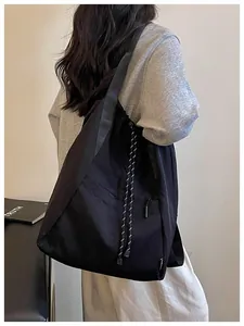 Vue détaillée d'un grand sac à dos noir léger avec cordon de serrage sur une personne