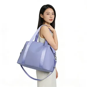 Professional model carrying a large lavender nylon travel bag with wide shoulder strap