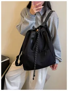 Sac à dos à cordon noir léger porté à l'épaule montrant le style et sa grande capacité
