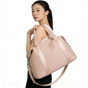 Large capacity pink nylon travel duffle bag for women with adjustable shoulder strap.