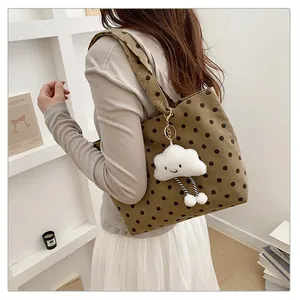 Detailansicht einer braunen Cord-Tragtasche mit Punkten und einem Wolken-Anhänger