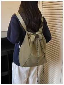 Vue arrière d'un grand sac à dos seau vert olive à cordon porté sur les épaules.