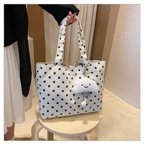 Detailansicht einer gepunkteten Canvas-Tote-Bag mit einem süßen Plüsch-Wolken-Anhänger