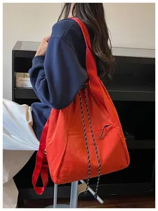 Grand sac cabas rouge-orangé à cordon avec cordons rayés et profil latéral du mannequin