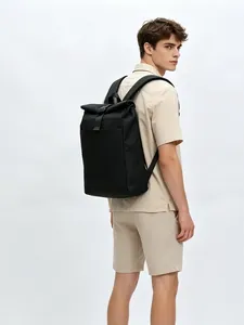 Back view detail of a sleek black roll-top backpack showing ergonomic straps and capacity