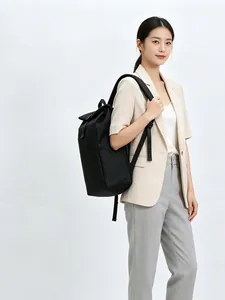 Detail view of a model carrying a minimalist black casual backpack with large capacity