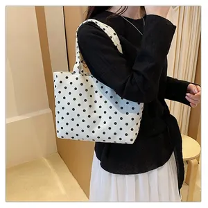 Moderner Canvas-Shopper mit Punktmuster, getragen als stilvolle Schultertasche