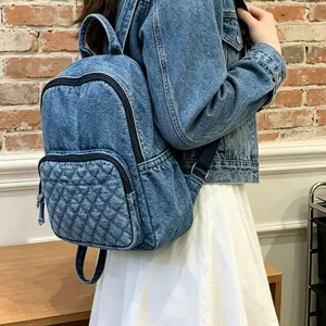 Vue arrière stylée d'un sac à dos en denim lavé décontracté avec poche matelassée