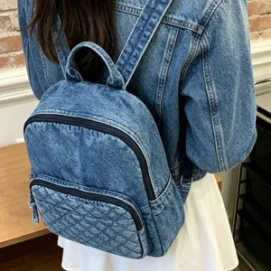 Vue arrière d'une femme portant un sac à dos en denim délavé bleu avec poche matelassée