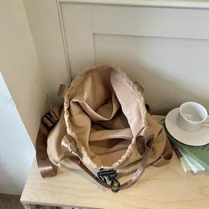 Sac à dos à cordon kaki léger montrant l'intérieur de grande capacité et poches