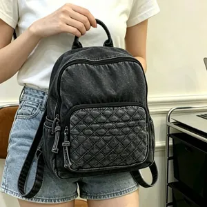 Gros plan d'un sac à dos en denim délavé noir pour femme avec poche matelassée
