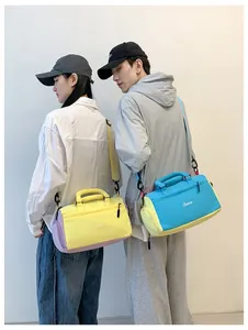 Asiatische Models präsentieren farbenfrohe Kontrastfarben-Reisetaschen für den Sport