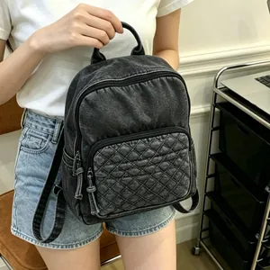 Sac à dos en denim noir délavé pour femme avec un design de poche avant matelassée