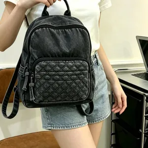 Sac à dos en denim noir lavé pour femme avec une poche avant matelassée très tendance.
