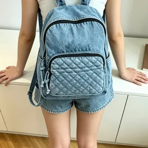 Vue détaillée de style de vie d'un sac à dos en denim délavé bleu avec poche matelassée
