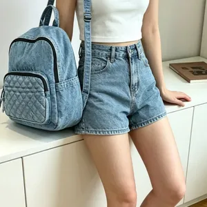 Détail d'un sac à dos en denim bleu clair élégant avec poche avant matelassée porté par un mannequin