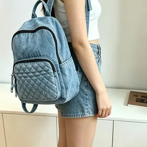 Sac à dos en denim bleu délavé décontracté avec poche avant matelassée sur un modèle